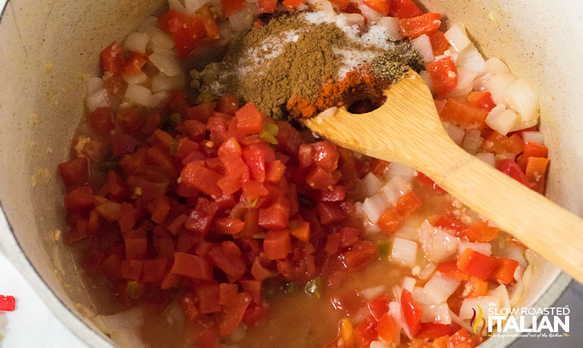 stirring spices into veggies in pot