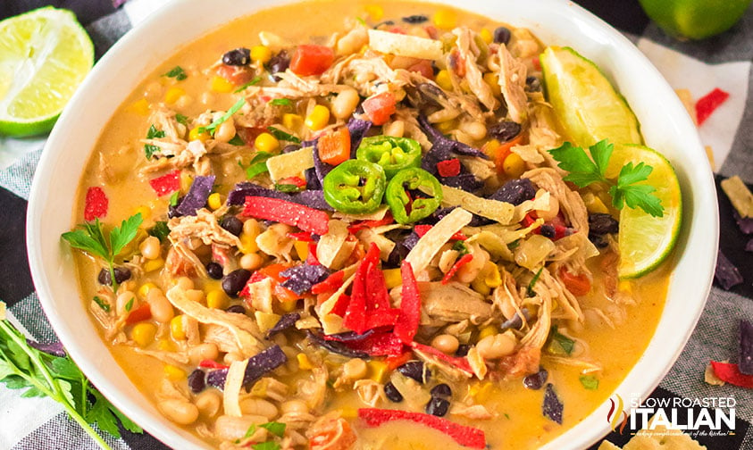 chicken tortilla soup topped with tortilla strips, jalapenos, and lime wedges