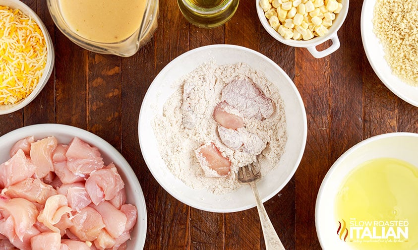 tossing chicken pieces in flour with fork