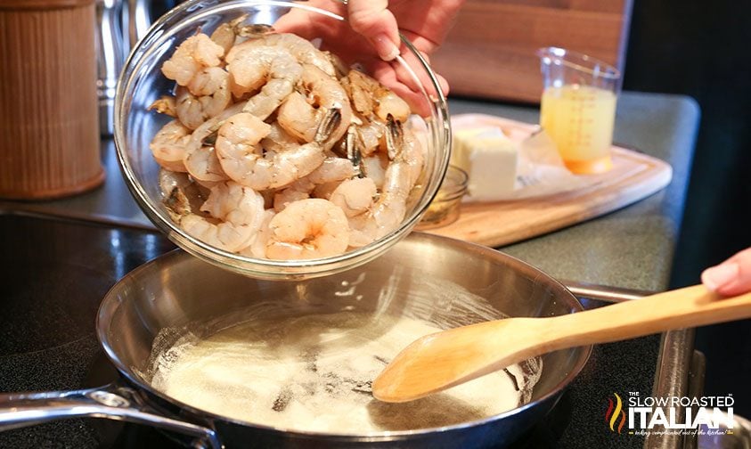 adding raw shrimp to skillet with melted butter