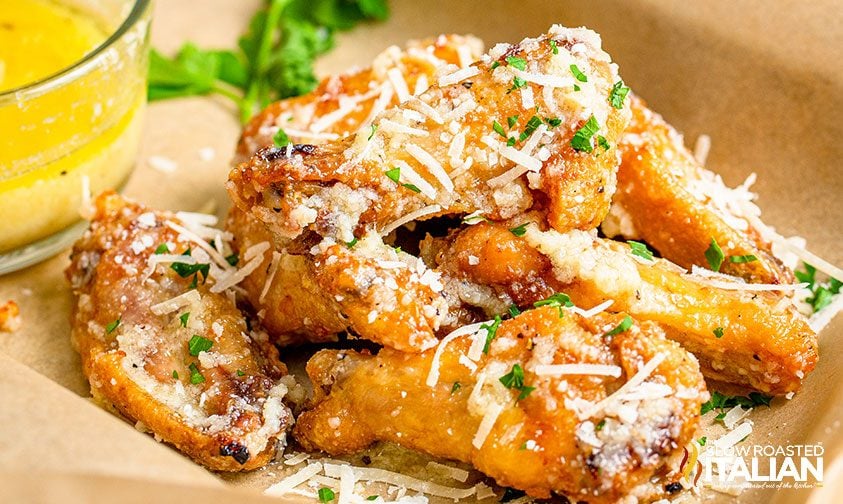 closeup: pile of garlic parm wings with fresh parsley