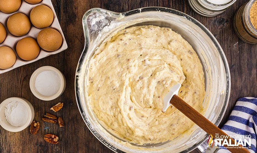 stirring cake batter with coconut and pecans