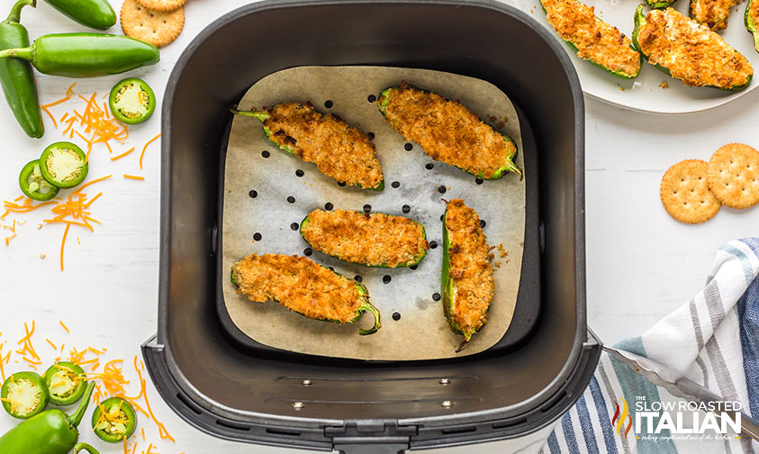 jalapeno poppers in air fryer basket lined with parchment