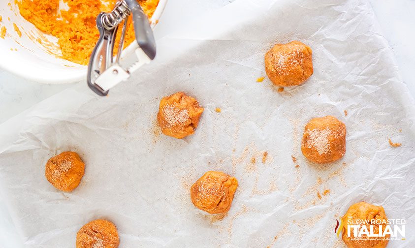 balls of cookie dough on parchment lined baking sheet