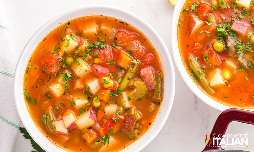 bowls of veggie soup garnished with herbs