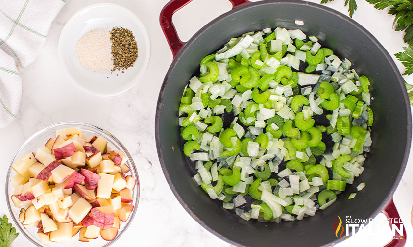 celery and onion in large pot next to bowl of potatoes