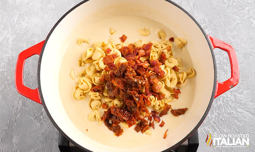 adding bacon and tortellini to cream sauce