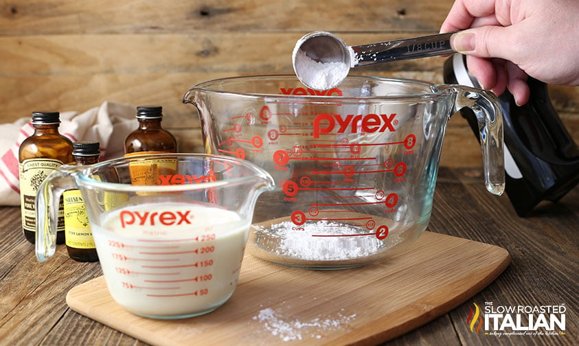 adding measured powdered sugar to glass bowl