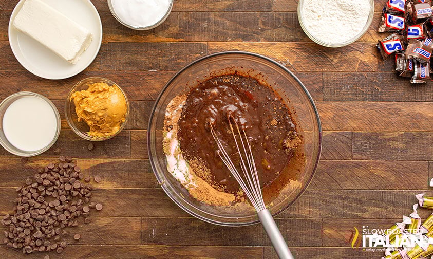 mixing batter for Outrageously Peanutty Snickers Brownies