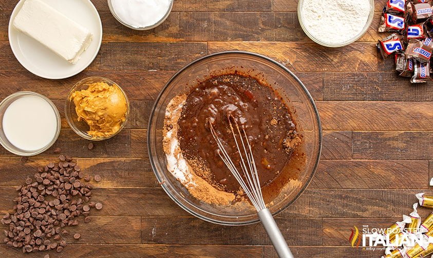 mixing batter for Outrageously Peanutty Snickers Brownies