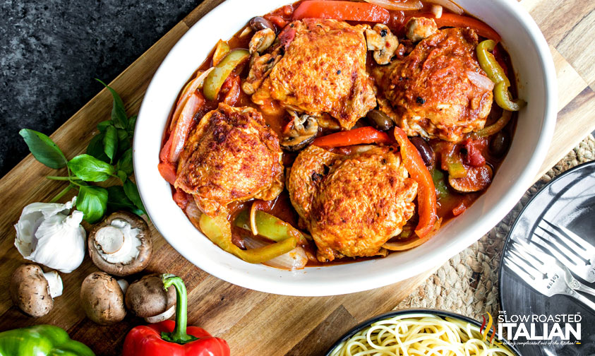 Slow Cooker Chicken Cacciatore in slow cooker with mushrooms and garlic on the side