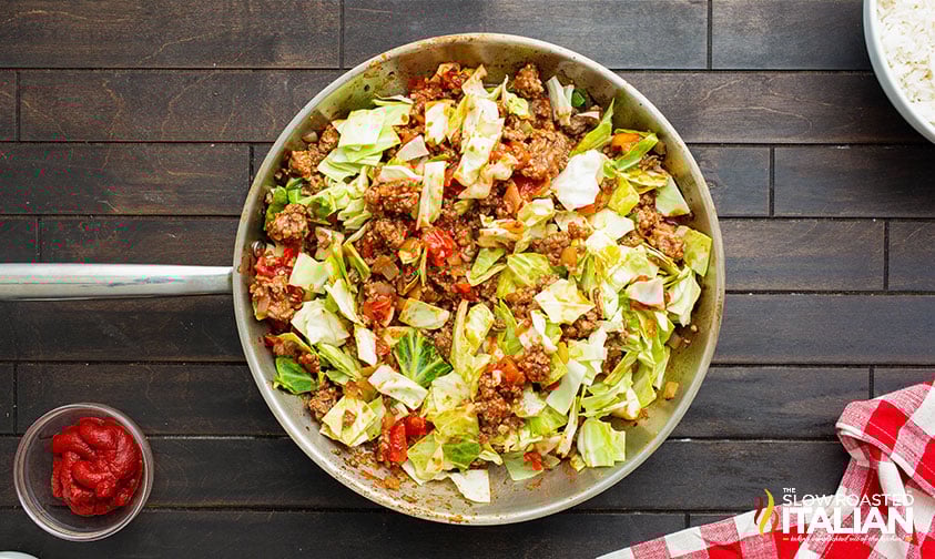 adding cabbage to the skillet