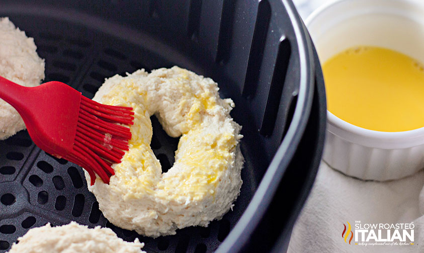 brushing egg wash over bagel dough in air fryer