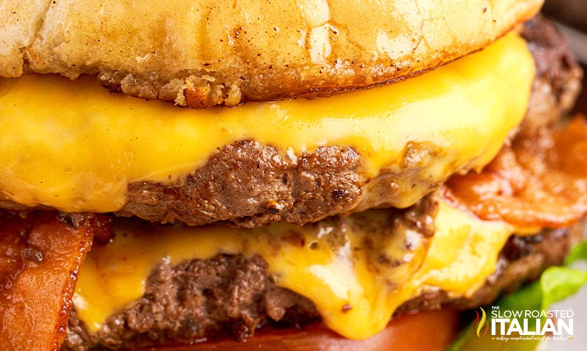 closeup: burger with two cheesy patties and bacon strips