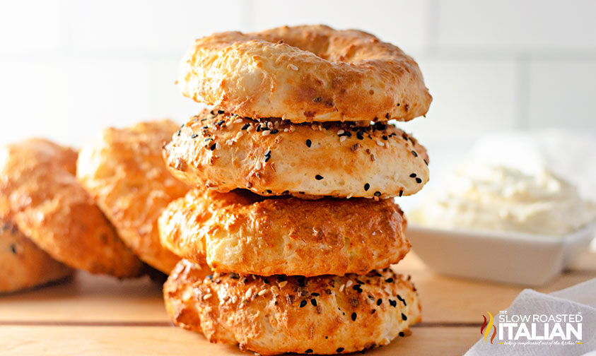 4 yogurt bagels stacked with cream cheese in background