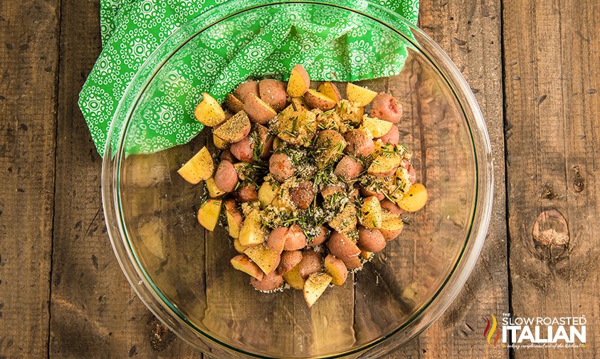 chopped red potatoes in bowl with seasonings