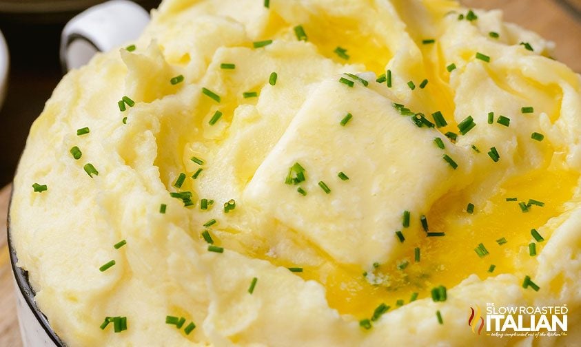 butter melting into pot of mashed potatoes with chives