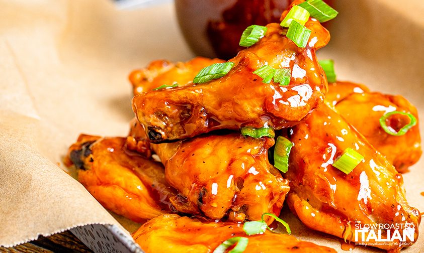 pile of honey bbq wings topped with green onion