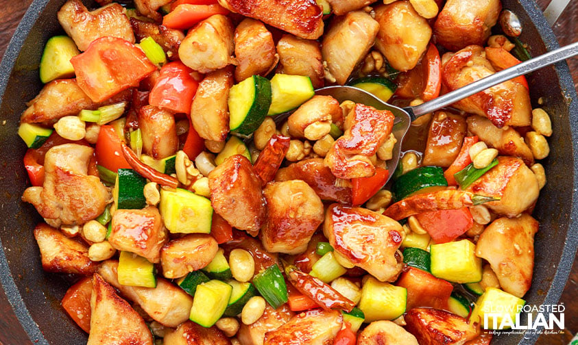 spooning copycat panda spicy chicken stir fry out of pan