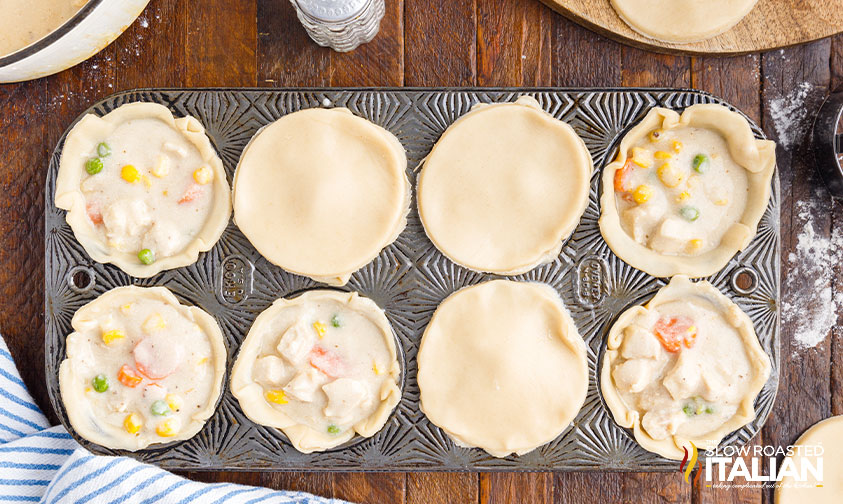 assembling mini pot pies in muffin tin