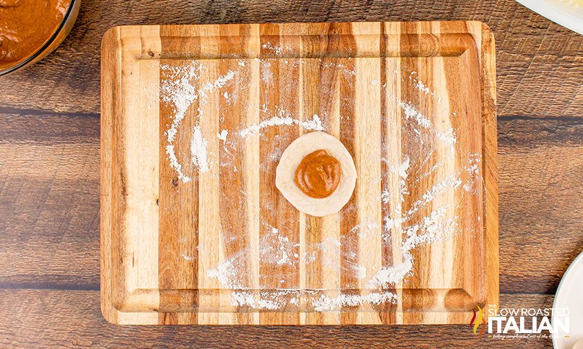 pumpkin pie filling in center of flattened dough disc