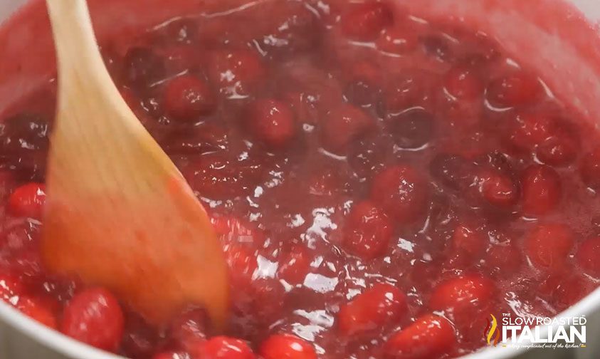 stirring homemade cranberry sauce