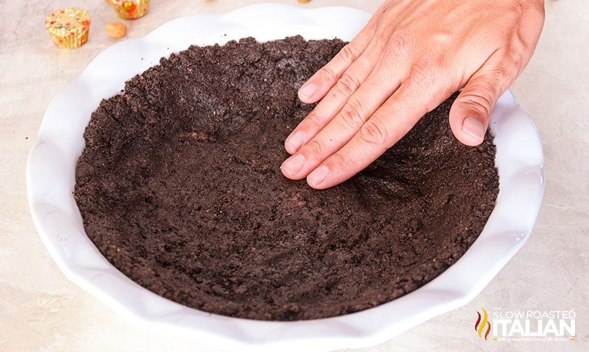 pressing chocolate cookie crust into pie plate