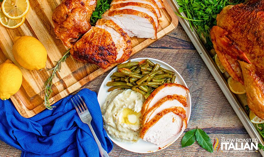 plate of smoked turkey, mashed potatoes, and green beans surrounded by meat