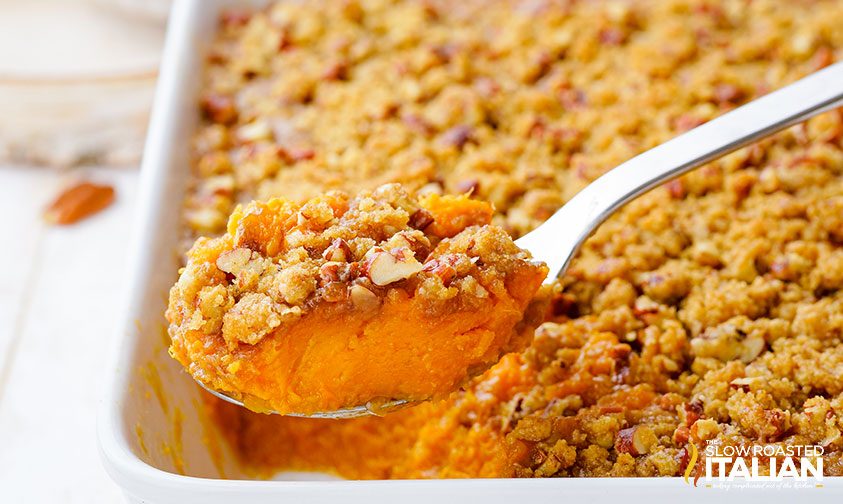 closeup: spoonful of sweet potato casserole with streusel topping