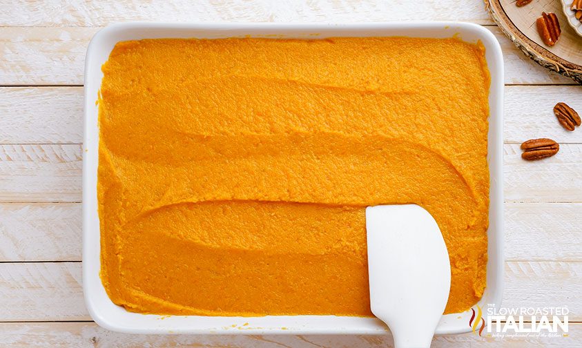 smoothing sweet potato mixture into baking dish