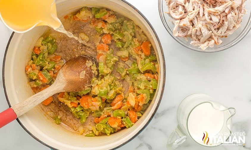 stirring turkey stock into flour coated veggies in pot