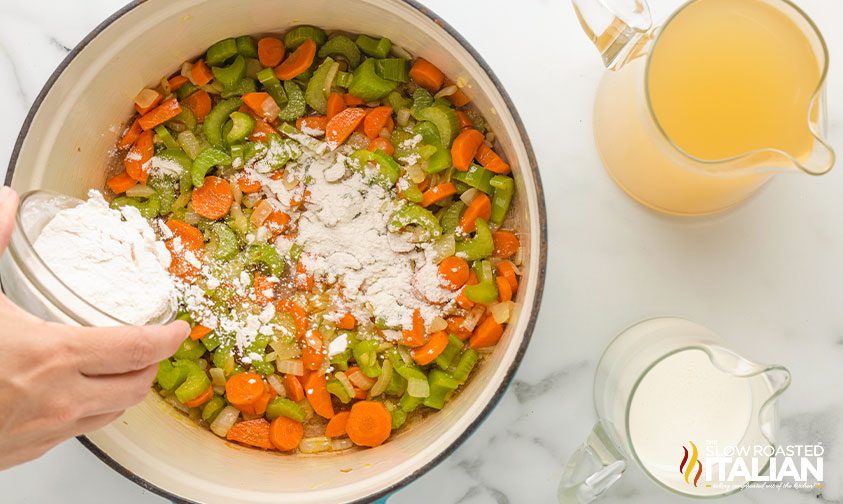 sprinkling flour over carrots, celery, and onion in pot