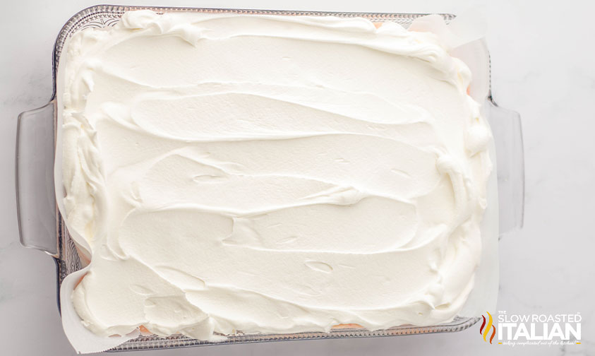 whipped topping on top of candy cane lush in baking dish