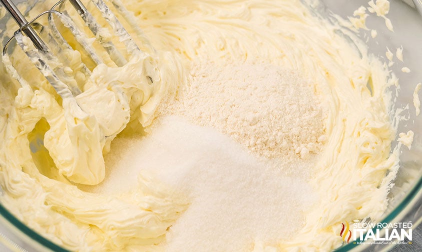 adding sugar and flour to cheesecake mixture