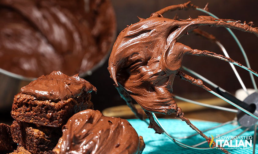 chocolate fudge icing on brownies and whisk