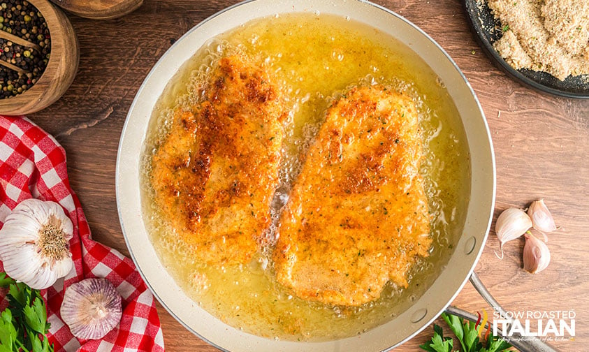 frying chicken in oil in a skillet