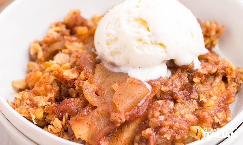 closeup of easy apple crisp in a bowl with a scoop of ice cream