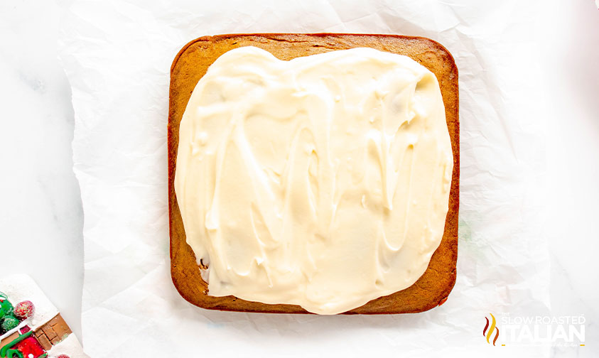 adding frosting to cingerbread cake