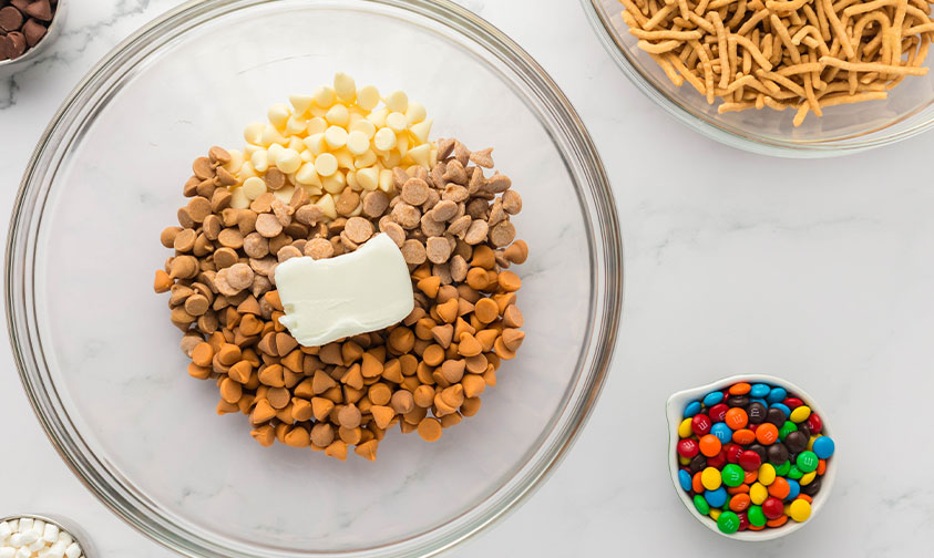 bowl of peanut butter chips, white chocolate chips and caramel chips with shortening