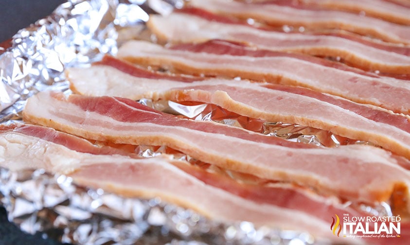 slices of bacon on aluminum foil baking sheet