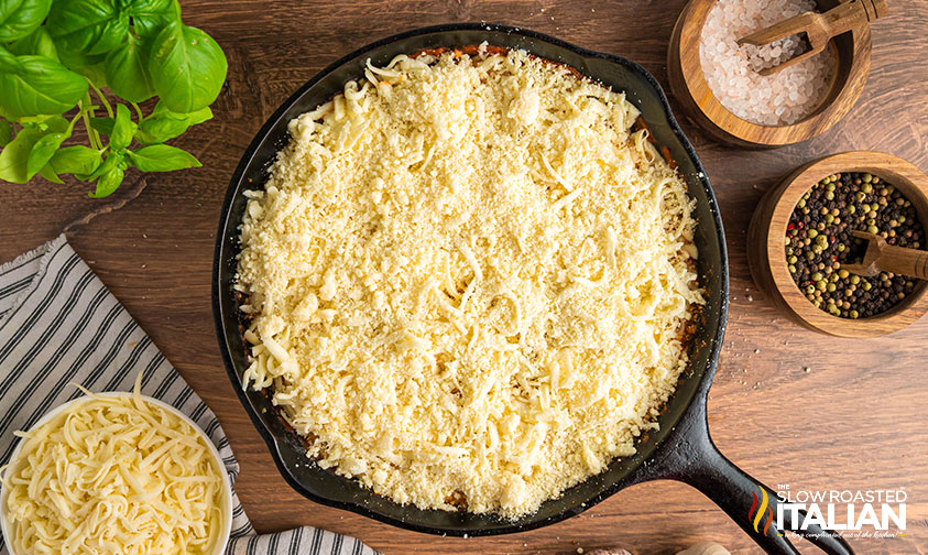 shredded mozzarella added to lasagna dip