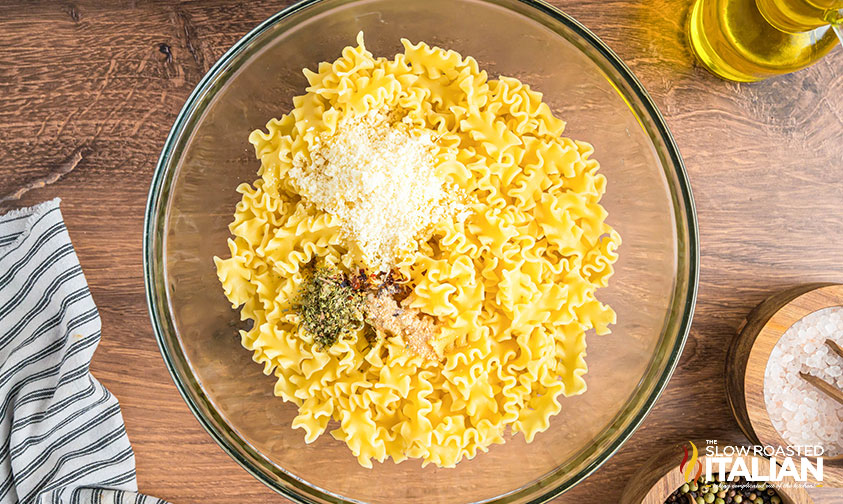 cooked pasta, olive oil and seasoning in a bowl