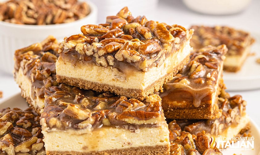 cut pecan cheesecake bars stacked on a plate