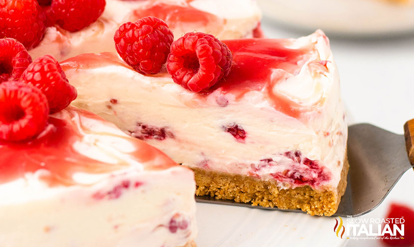 closeup of raspberry cheesecake with fresh raspberries