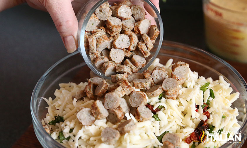 adding sliced sausage to bowl of ingredients