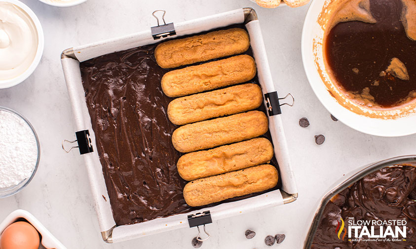 ladyfinger cookies on top of brownie batter