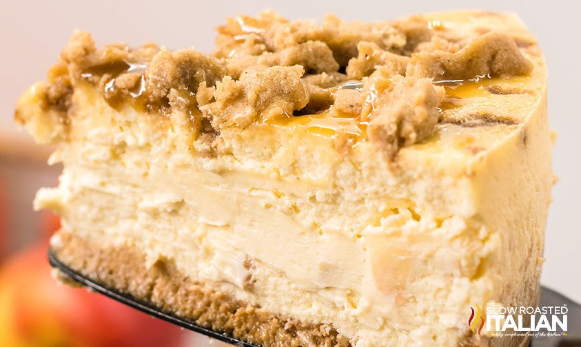 closeup of a slice of apple cheesecake with caramel and crisp topping