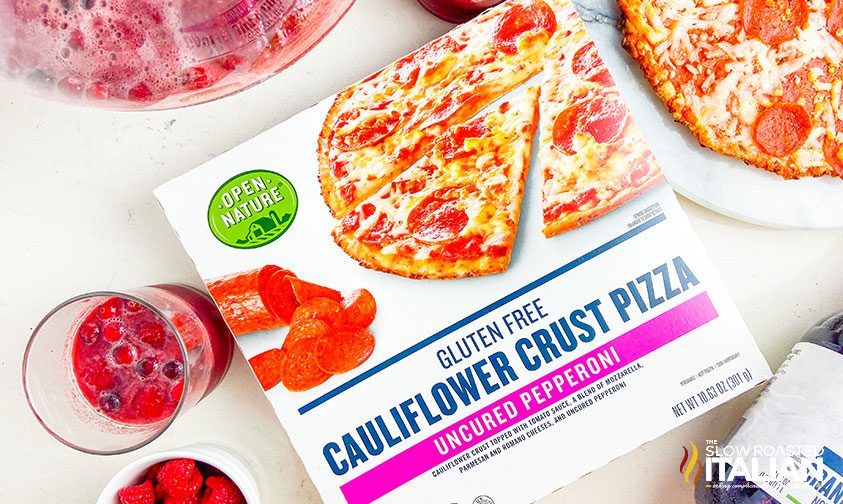 box of frozen pizza with a glass of cranberry punch