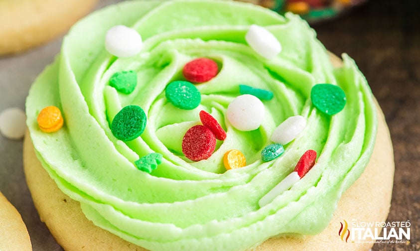 round sugar cookie with piped green frosting and sprinkles