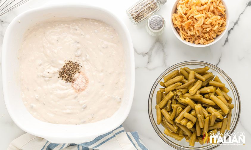 condensed cream of mushroom soup in casserole dish next to bowls of green beans and French's fried onions